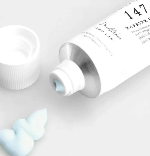 DR. ALTHEA 147 Barrier Cream - tube ouvert avec le capuchon retiré et de la crème bleu clair à côté